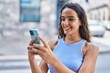 © Krakenimages.com - Young beautiful hispanic woman smiling confident using smartphone at street