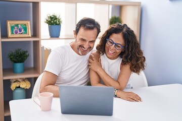 Canvas Print - Man and woman couple smiling confident using laptop at home