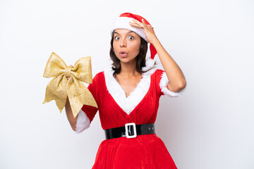 Wall Mural - Young hispanic woman dressed as mama noel holding a Christmas bow isolated on white background doing surprise gesture while looking to the side