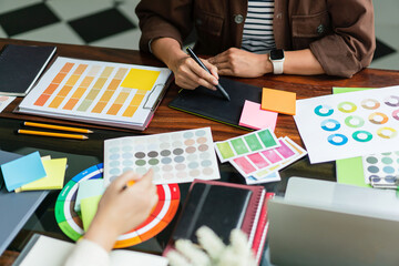 Poster - two creative graphic designers discuss about color swatch to designing project and sketch on tablet