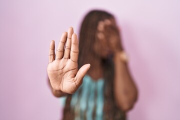 Poster - African american woman standing over pink background covering eyes with hands and doing stop gesture with sad and fear expression. embarrassed and negative concept.