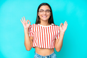 Wall Mural - Young caucasian woman isolated on blue background in zen pose