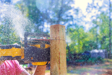 Wall Mural - Cutting wooden post for fence with an electric saw