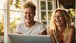 Young multiracial friends laughing looking at laptop sitting in beautiful bright space, friends using online services on internet, technology lifestyle concept, space for text