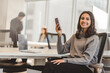 © Maria Vitkovska - Portrait of confident indian business woman wearing casual clothes holding smartphone