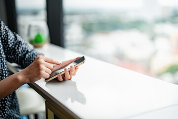 Wall Mural - woman using cellphone device texting browsing internet at workplace.