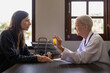 © Natee Meepian - Senior woman doctor and female patient talking recommend pill medical prescription at doctor office. Hospital, medicine and healthcare
