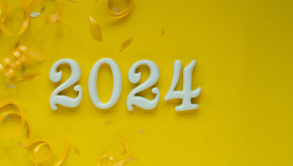 Wall Mural - close up number 2024 shape wood onyellow color background with gold rolling ribbon and confetti for 