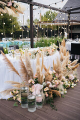 Wall Mural - Wedding ceremony. Presidium for the newlyweds, decorated with candles and vases with white and pink natural flowers such as eustoma, roses and reed. Floristic concept 