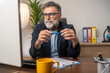 © Nenad - Confident mature man explain something looking at pc camera while doing video call in the office at home. Serious businessman working on computer. Male professional is planning strategy