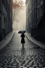 Poster -  a woman with an umbrella walks down a cobblestone street in the rain in a black and white photo.