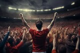 Fototapeta Fototapety sport - A football/soccer player scoring a breathtaking goal in a packed stadium, celebrating with fans