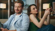 © stockbusters - Love couple using gadgets cozy house zoom on. Woman showing mobile phone to man