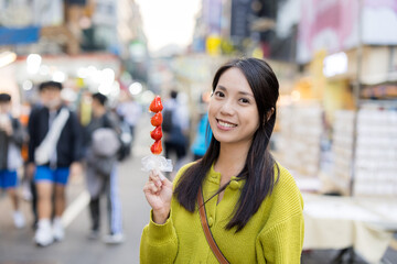 Wall Mural - Woman hold with Tanghulu traditional Chinese hard caramel coated strawberry skewer