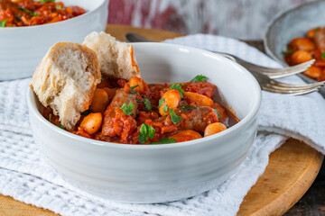 Wall Mural - Beef chipolatas and bean casserole with crusty bread