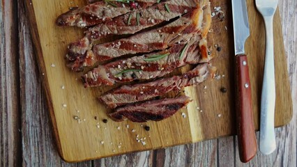 Sticker - T bone beef steak grill sliced on a board. Top view. Close up. 