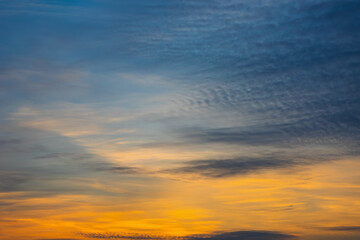 Wall Mural - majestic dusk. beautiful dark blue sky with vivid golden shades. dense clouds in twilight orange sky