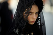 Portrait of young beautiful woman wearing traditional dress during church procession in Spanish city street