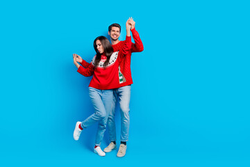 Poster - Full length photo of lovely young spouses energetic dancing hold hands wear x-mas ornament red sweaters isolated on blue color background