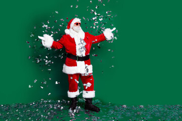 Wall Mural - Full length photo of elderly retired man hands falling confetti dressed stylish santa claus costume coat isolated on green color background