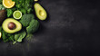 Fresh green vegetables and citrus fruits on a dark slate background
