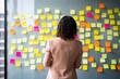 © Adriana - woman looking at sticky notes in the wall