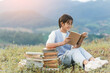 © AungMyo - Beautiful young teenage girl with glasses reading a book in the park sunset background