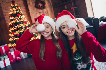 Poster - Photo of cheerful tricky little siblings dressed ugly print christmas jumpers cap baubon cover eyes indoors house room