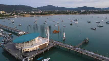 Wall Mural - Aerial drone view of Chalong Pier in Phuket, Thailand. Many boats, yachts, catamarans and speed boats moored at the pier platform of Ao Chalong Bay, one of centers to travel around Andaman Sea.