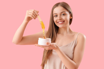 Wall Mural - Pretty young woman with sugaring paste on pink background