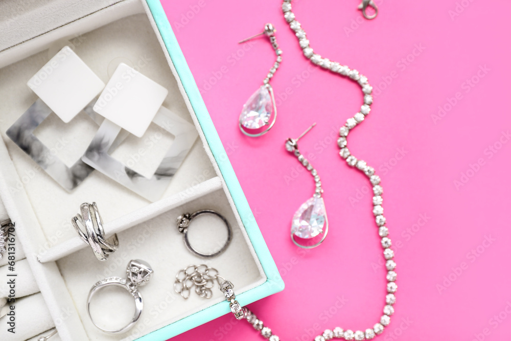 Organizer with stylish jewelry on pink background