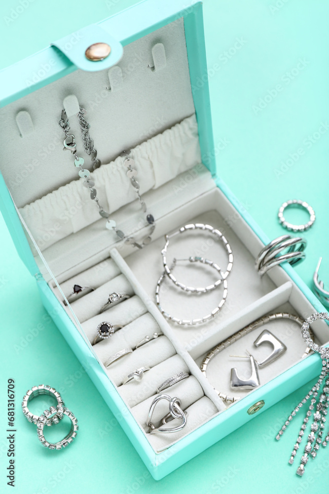 Organizer with stylish jewelry on turquoise background