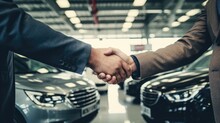 defocused handshake in an automotive workshop, with car prototypes and mechanics in the background, in an automobile industry