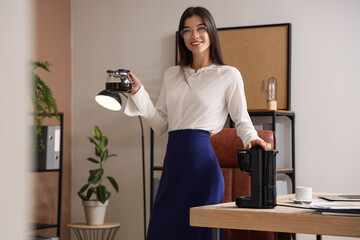 Poster - Young businesswoman with coffee machine pot in office