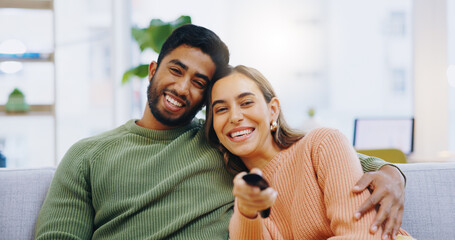 Poster - Couple, watching tv and remote on living room couch with smile, hug or relax with click for choice, show or film. Man, woman and happy together for embrace, movie or streaming on lounge sofa in home