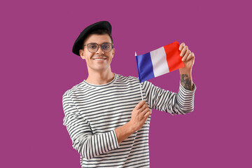 Wall Mural - Young man with flag of France on purple background