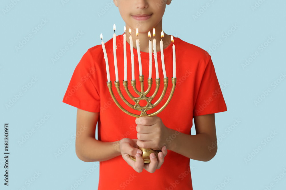 Little Israeli boy with menorah on blue background