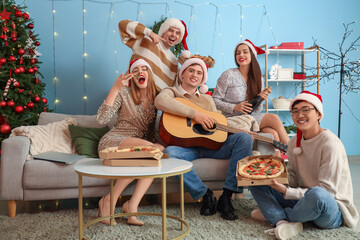 Wall Mural - Group of young friends celebrating Christmas at home party