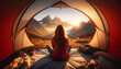 Woman in red jacket sits inside a tent at sunrise, facing majestic mountains. The warm morning glow enhances the cozy tent setting. Breathtaking views of clear skies and mountain ridges.