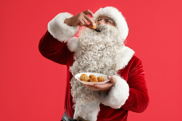 Sticker - Santa Claus eating tasty falafel balls on red background