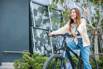 Happy Asian young woman riding bicycle on street outdoor near building city, Portrait of smiling female lifestyle use mountain bike in summer travel means of transportation, ECO friendly, Urban biking