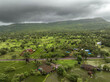 View of Alibag  Village in monsoon season at Konkan, Maharashtra, India. Traditional Indian village house surrounded by green grass and beautiful cloudy blue sky. Village landscape.