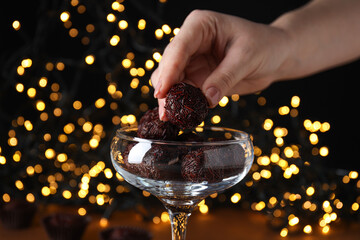 Wall Mural - Brigadeiro in cocktail glass and female hand on dark background