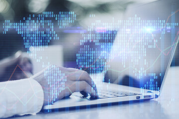 Close up of male hands using laptop at light workplace with coffee cup and glowing digital pixel squares map of the world on blurry background. Global business concept. Double exposure.