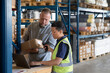 © ReeldealHD images - Employee in distribution warehouse being trained on paperwork to export products