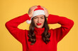 canvas print picture - woman in Santa hat suffering with headache against yellow backdrop
