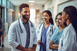 © Bojan - Diverse group of smiling doctors standing together in a hospital corridor having informal discussion.