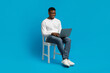 © Prostock-studio - African american guy sitting on chair and using modern notebook