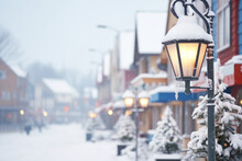 The Charm Of Town During Snowfall, With Snow-covered Rooftops, Streets, And Lampposts Creating Cozy And Nostalgic Scene