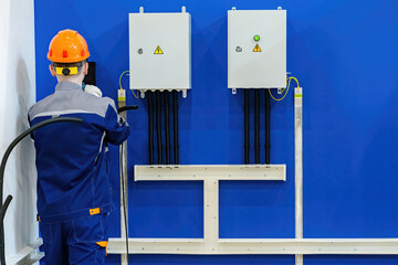 Poster - electrical installation work. man electrician with power wire. installation of electrical wiring ins